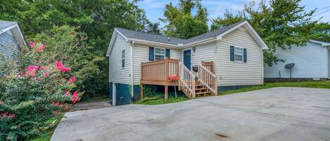 A single-story mobile home with a front porch and a small staircase.
