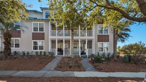 A two-story building with a front porch, a covered entryway, and a landscaped front yard. - Pool, Fitness Center & Central Location (Santa Rosa Beach)