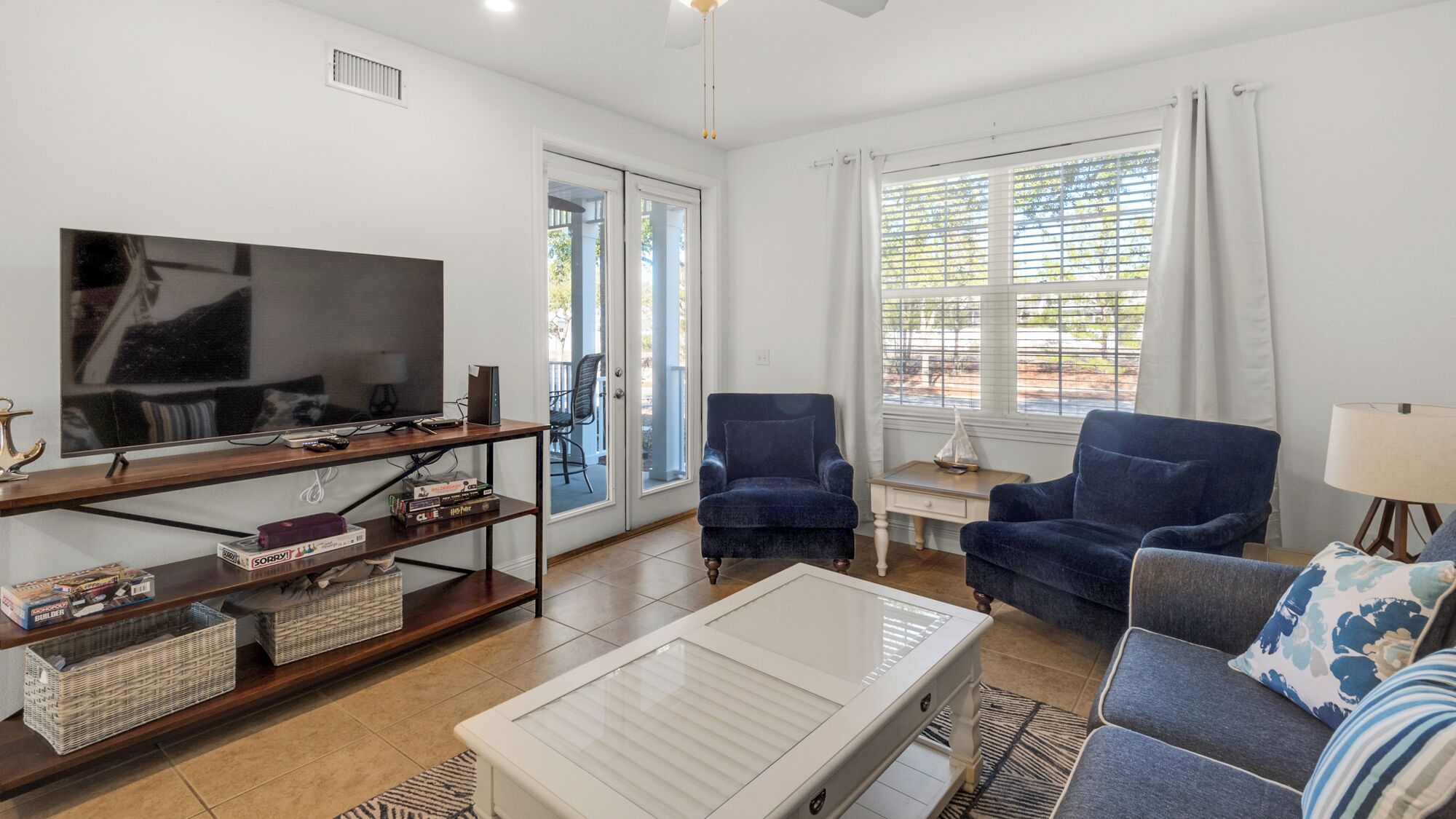 A living room with a TV, a sofa, a chair, and a coffee table.