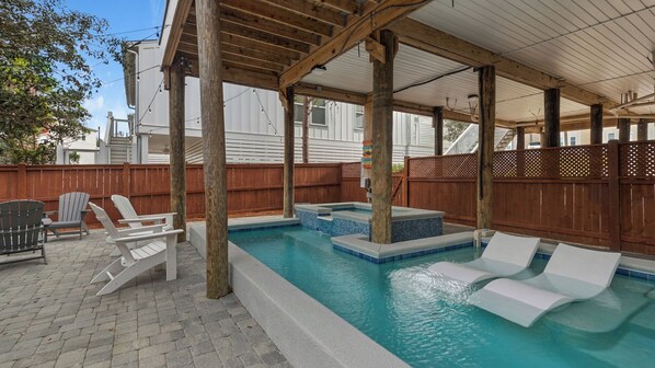 Piscina ao ar livre coberta com espreguiçadeiras e um deck de madeira.