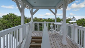 A covered wooden deck with white railings and a small table and chairs. - Private Pool and Gulf Side in Seagrove + Beach Service (Santa Rosa Beach)