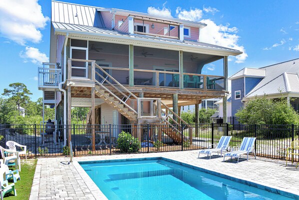 A two-story house with a swimming pool, a covered deck, and a fenced backyard. - Turtle Town: View | Private Pool | Screen Deck (Cape San Blas)