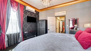 Une chambre d’hôtel avec un grand lit, un téléviseur à écran plat, une armoire et un miroir.
