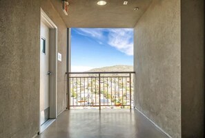 Stroll through this corridor to a balcony with a serene view of the surrounding hills.