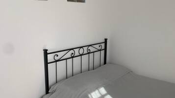 A bedroom with a bed, a nightstand, and a wall with abstract art.