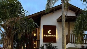 Um edifício com uma placa que diz “BUENA ONDA Pousada & Restaurante”, indicando um estabelecimento de restaurante e lounge.