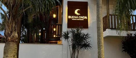 A building with a sign reading "BUENA ONDA POUSADA & RESTAURANTE" indicating a restaurant and lounge facility.