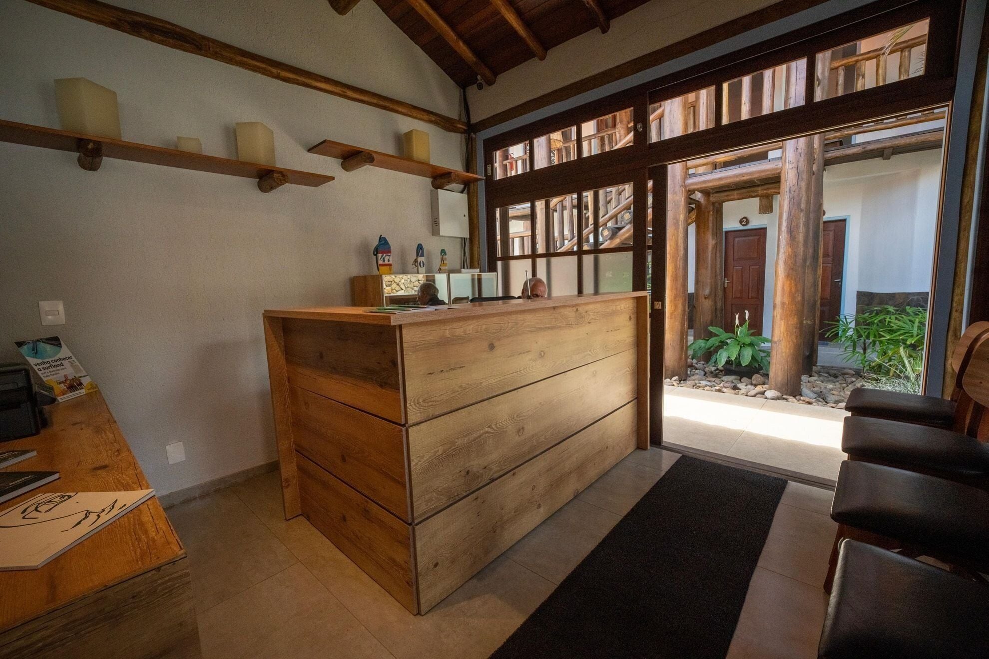 A reception desk with wooden drawers, a bulletin board, and a small plant.
