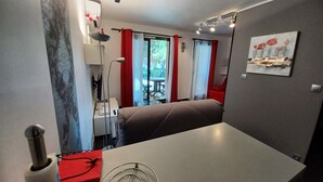 A modern hotel room with a bed, a dining table, a lamp, and a view of the outdoors. - Beau Studio à 150 m de la mer Dans un Parc Privé ! (Six-Fours-les-Plages)