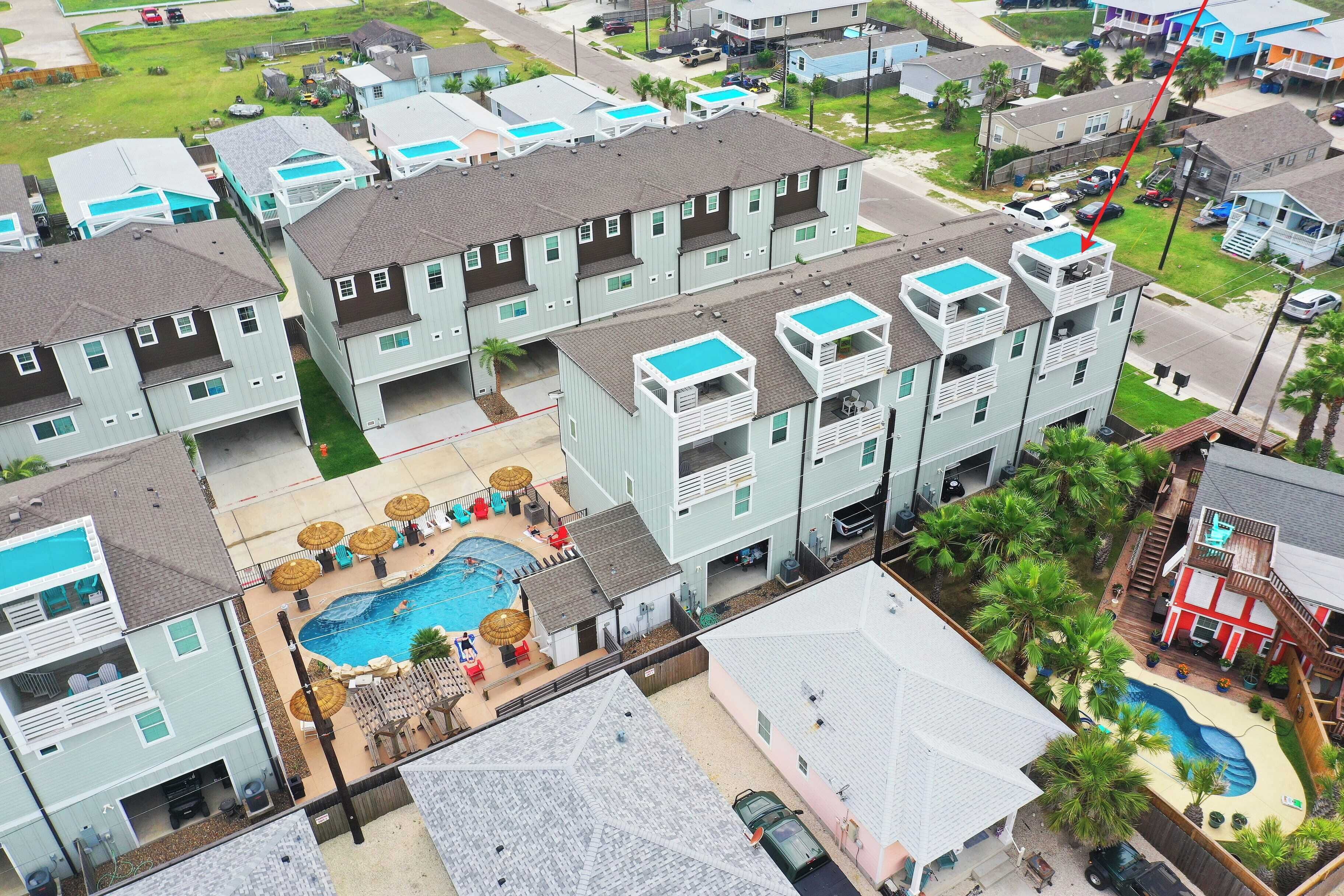 A multi-story residential building with a swimming pool and outdoor seating area.