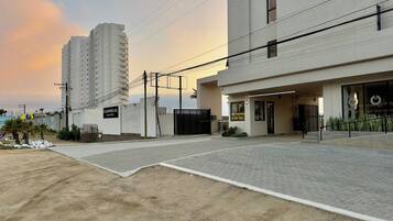 A modern building with a paved entrance and a sign indicating 'CANDELIA'.