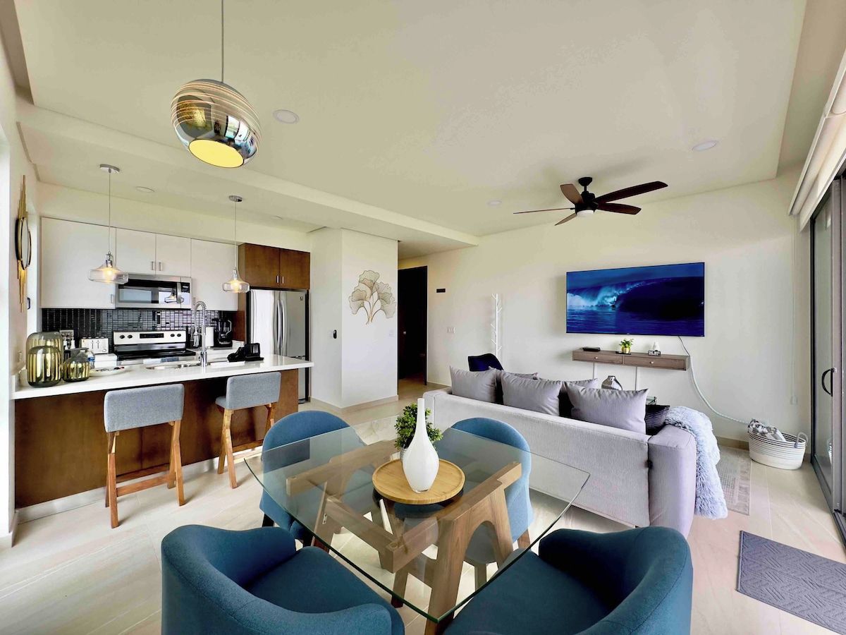 A modern living space with a kitchen, dining area, and a sofa.