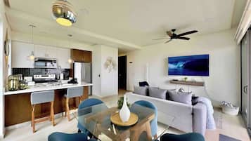 A modern living space with a kitchen, dining area, and a sofa.