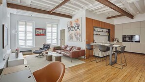 Un salon moderne comprenant un canapé, une table basse et un coin repas avec des chaises.