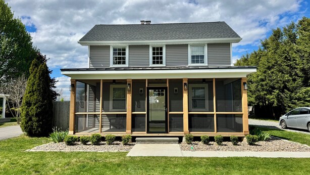 A two-story house with a covered porch, a front door, and a driveway. - Family home by Polo fields with great yard & game rm. EV charger, pet friendly! (Pine Plains)