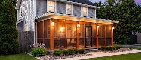 A two-story house with a covered porch, a fenced yard, and a well-maintained lawn.