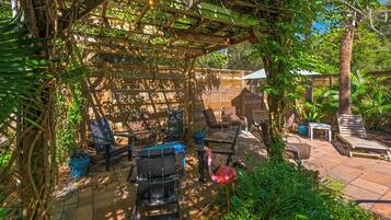 Un patio cubierto con arreglos de asientos y una estructura de pérgola.