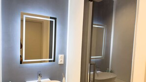 A bathroom with a double sink, a mirror, and a towel rack.