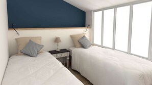 A bedroom with two beds, a nightstand, a lamp, and a window.