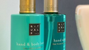 Two bottles of hand and body lotion with pumps, labeled 'RITUALS'.