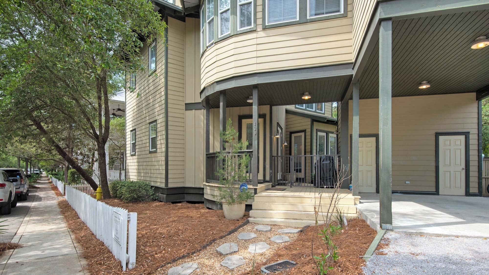 A two-story building with a covered porch and a driveway.