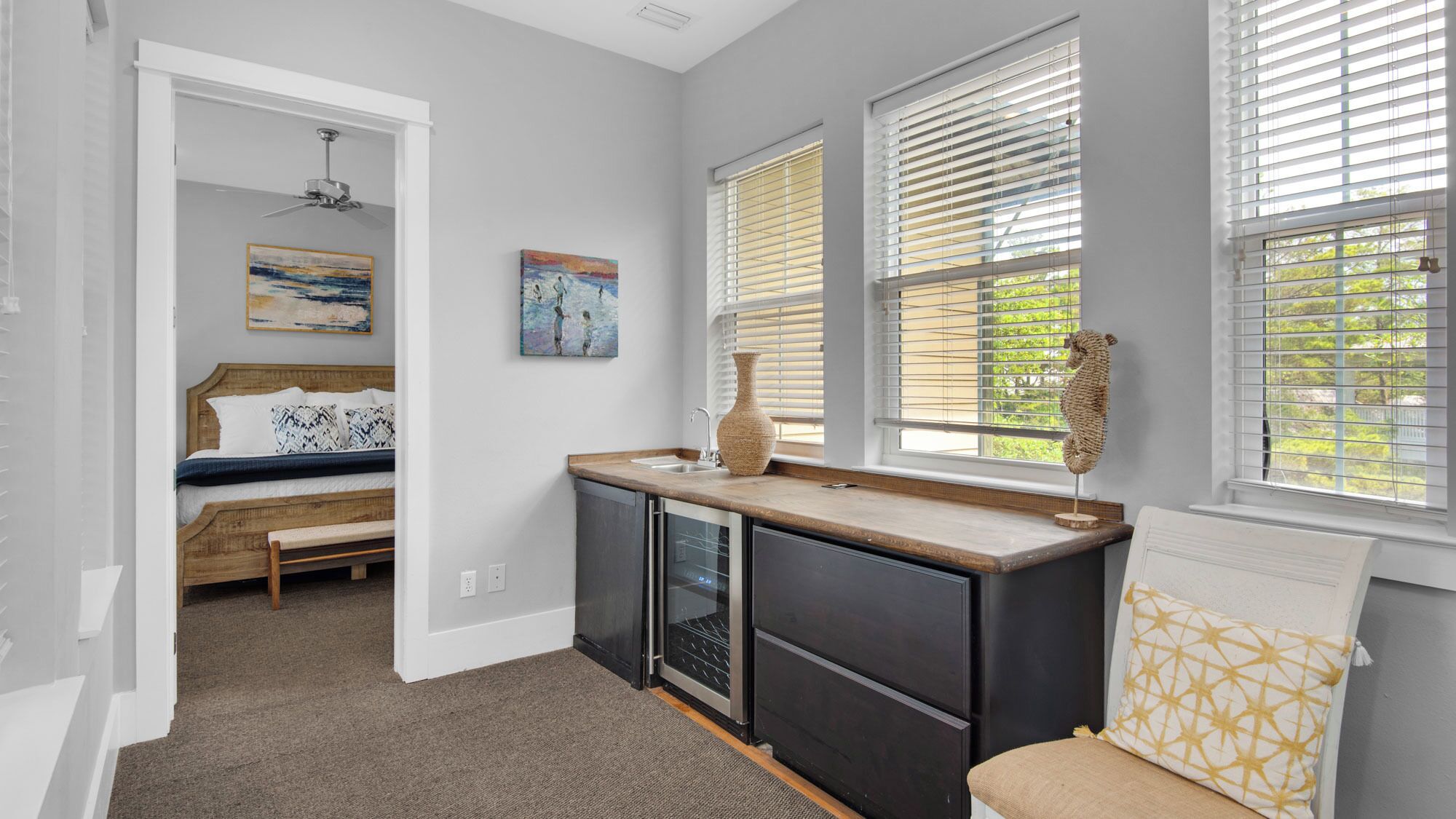 Un dormitorio pequeño con cama, una kitchenette y una ventana con persianas.