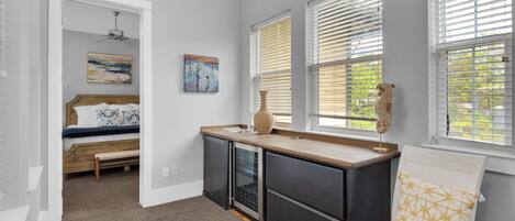 Un dormitorio pequeño con cama, una kitchenette y una ventana con persianas.