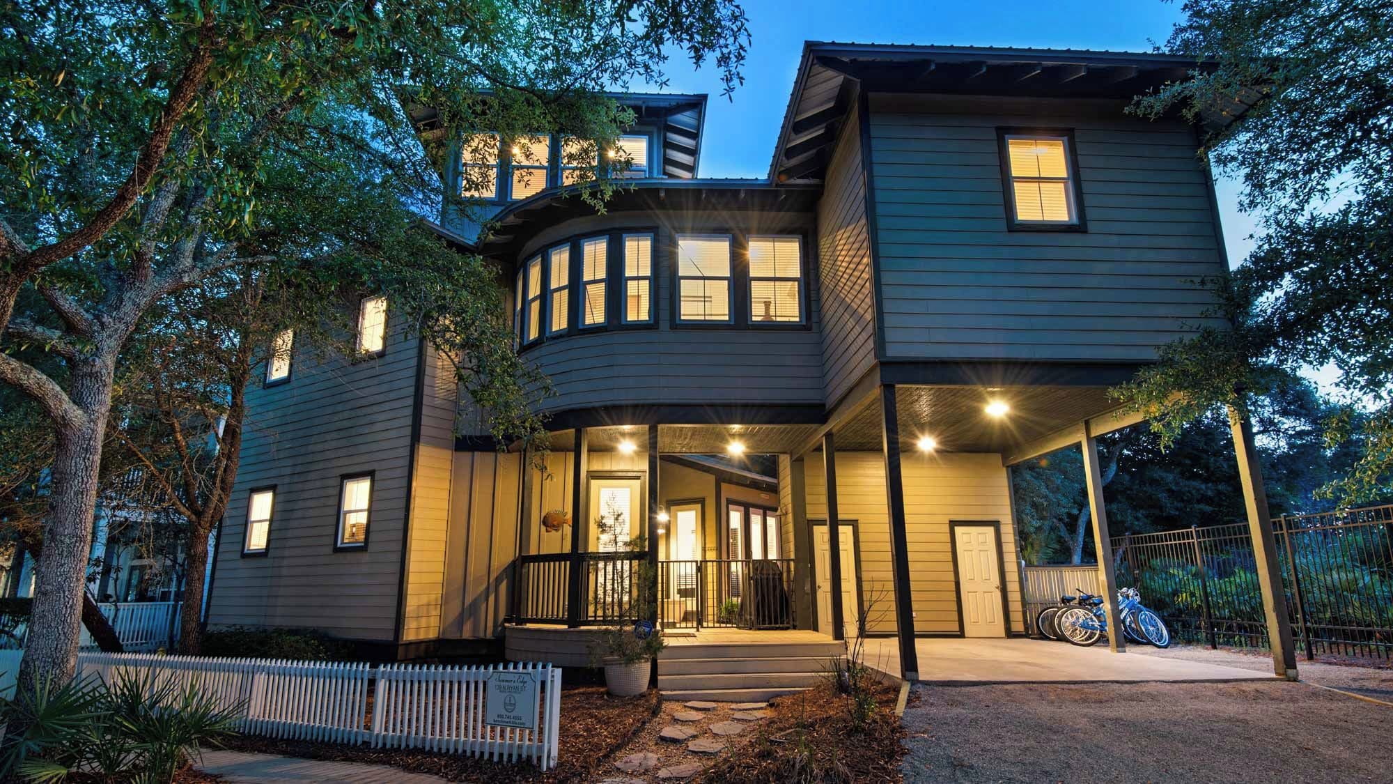 A multi-story house with a porch, a garage, and a driveway.