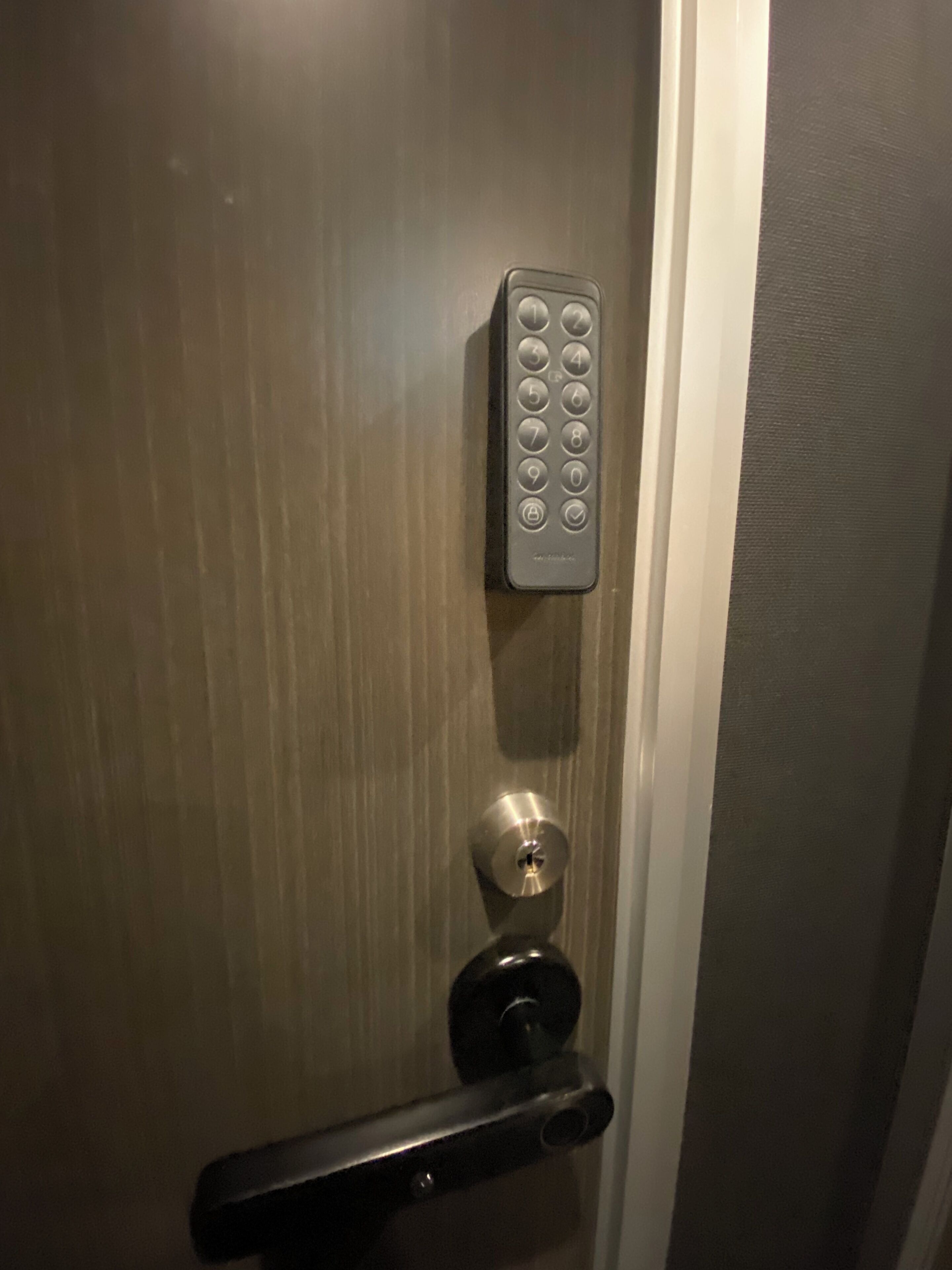 A door with a keypad lock and a keyhole.