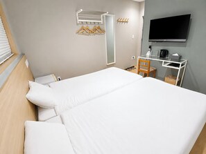 A hotel room with a bed, a TV, a desk with a chair, and a coat rack. - My Home Inn Sennan Onosato (Sennan)