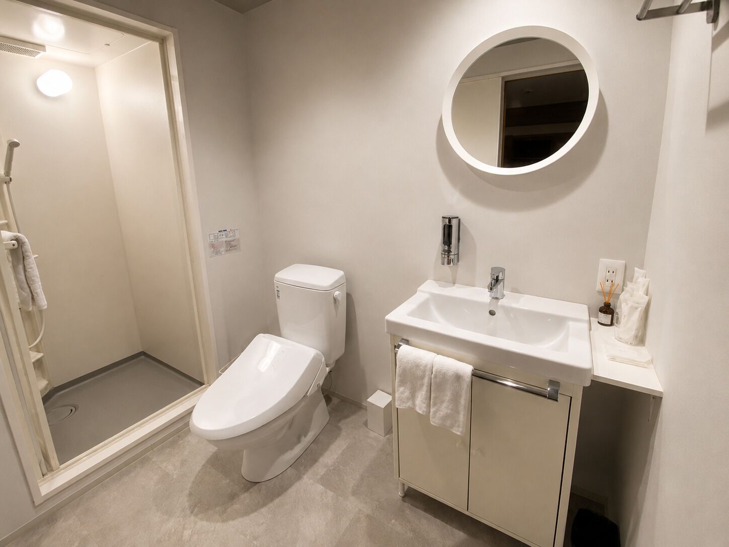 A modern bathroom with a toilet, sink, and shower.