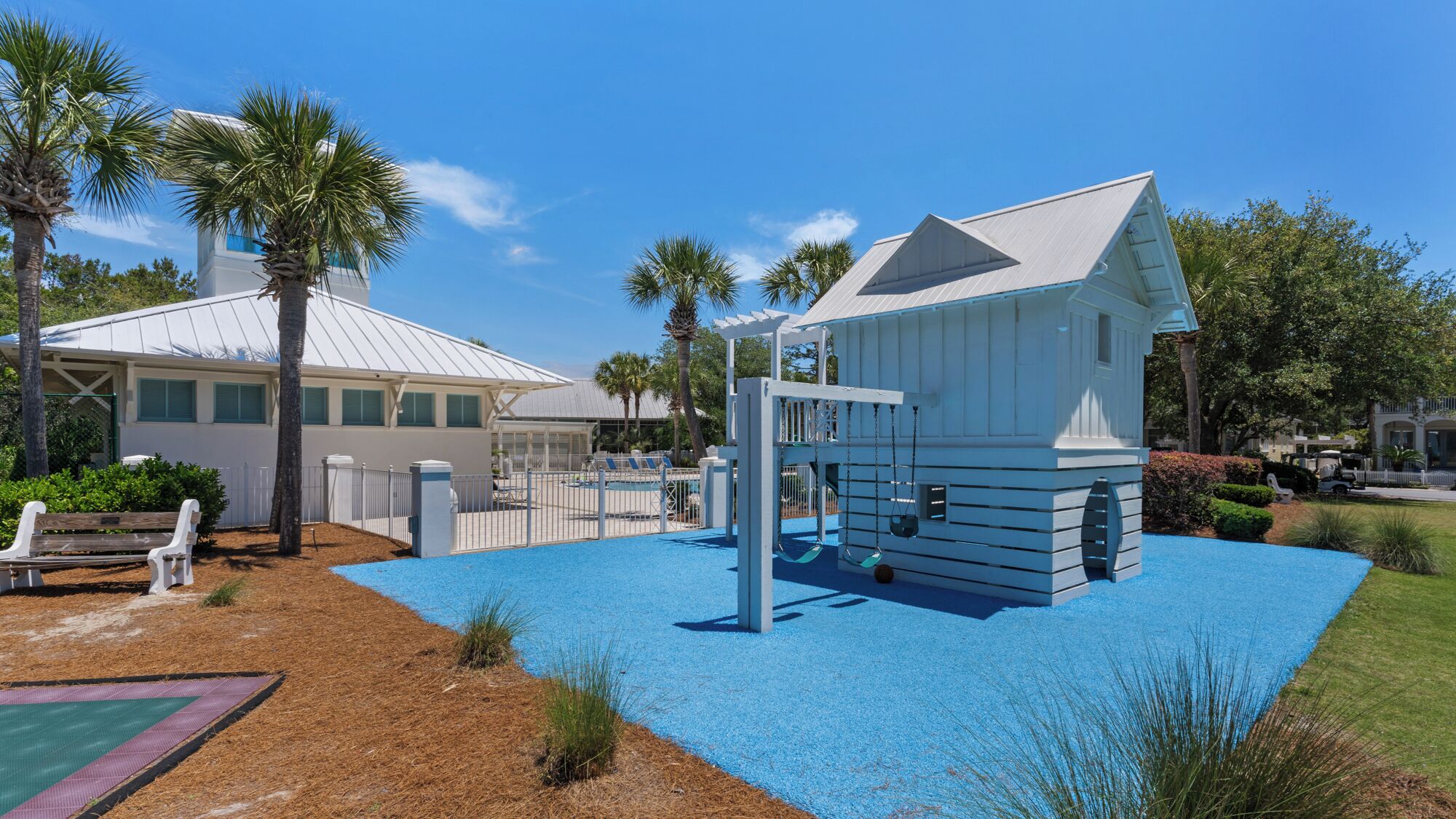 A playground with a swing set and a small house-like structure.