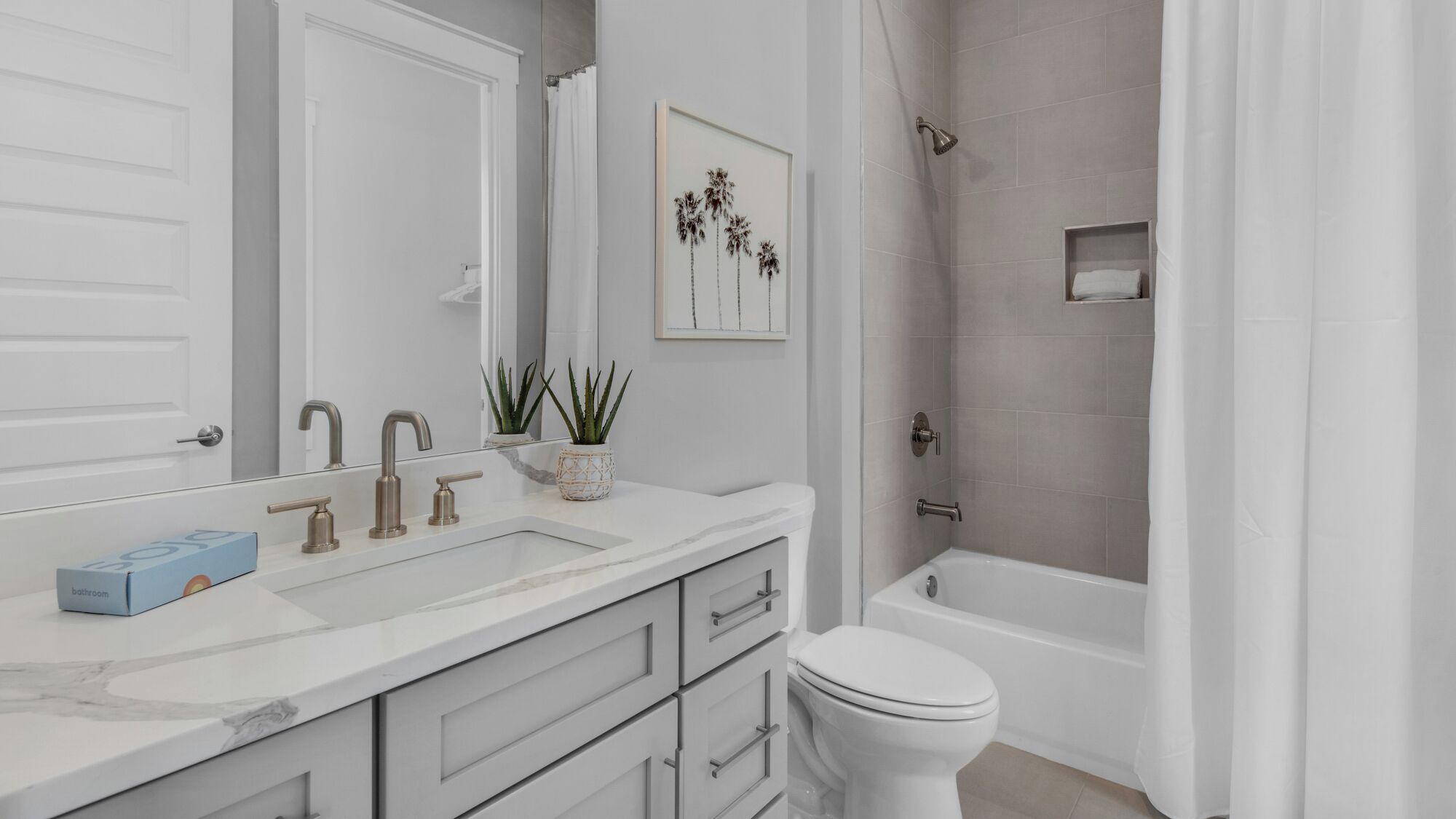 Une salle de bain moderne avec un meuble-lavabo blanc, une baignoire et des toilettes.