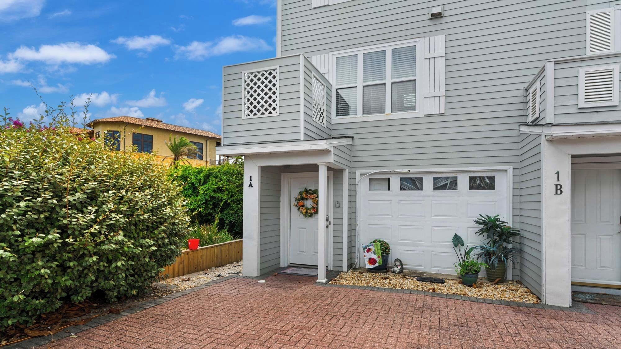 A two-story house with a front porch, a garage, and a well-maintained garden.