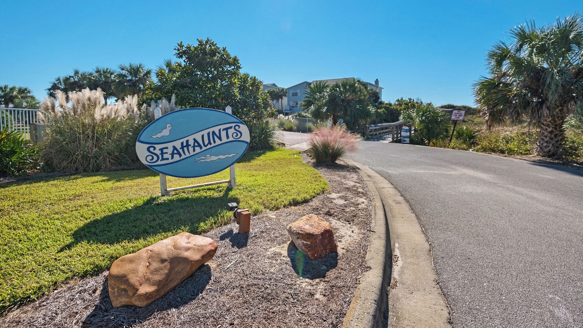 A sign for Seahalints with a clear road and residential buildings in the background.