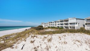 A beachfront hotel with multiple balconies, a sandy beach, and ocean views. - Modern & Updated - Gulf-front - Steps to the Beach (Santa Rosa Beach)