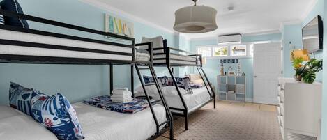 A bunk bed room with a nautical theme, including sailboat pillows and a lighthouse picture.