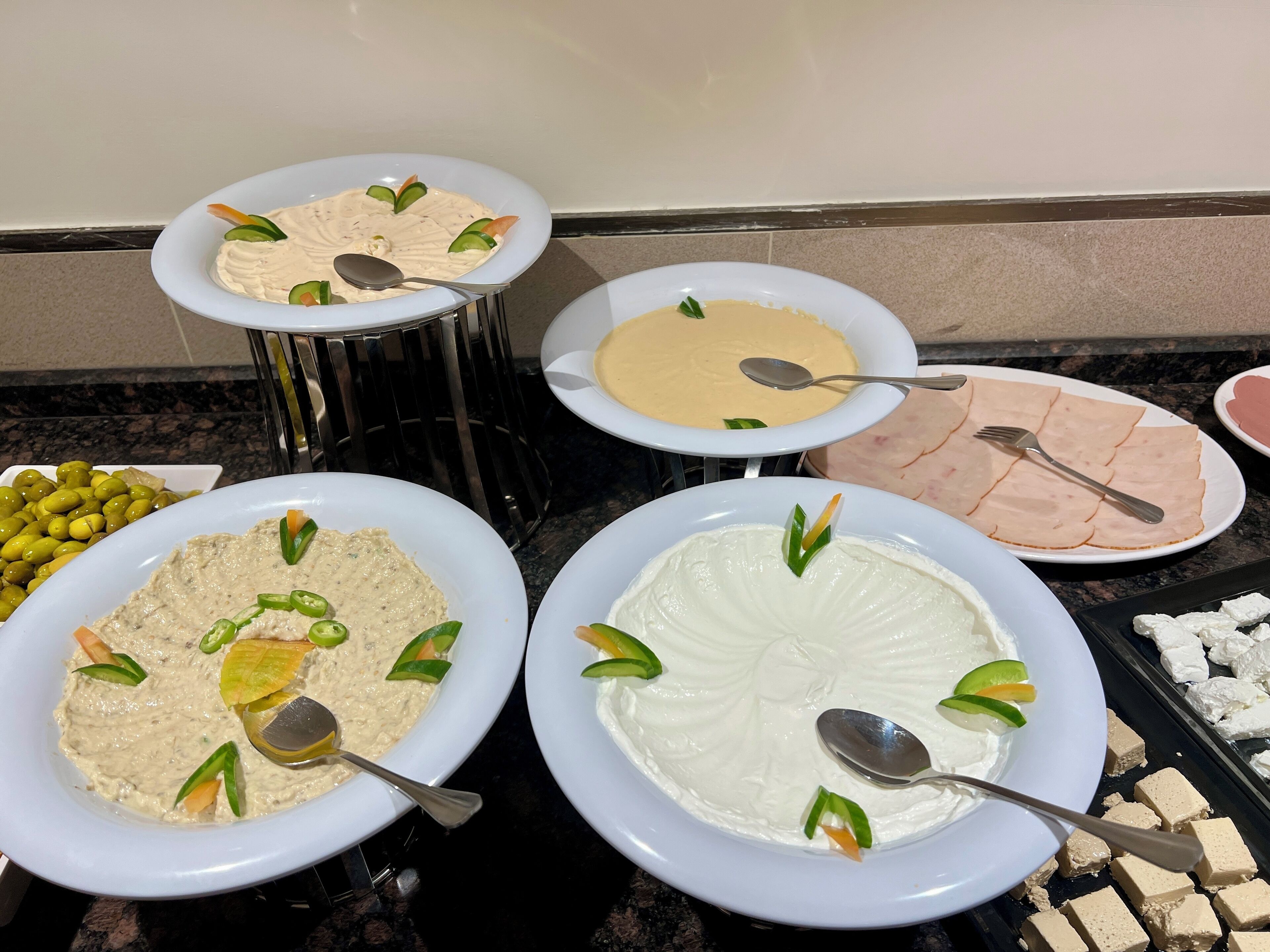 Buffet com diversos pratos, incluindo patês, carnes e queijos.