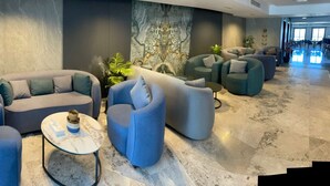 Un espace de détente moderne, avec des canapés, des fauteuils et une table basse.
