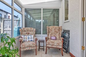 Relax in a cozy corner with a view, featuring two plush armchairs and a potted plant.