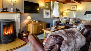 Una sala de estar acogedora con chimenea, muebles de cuero y decoración rústica.