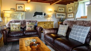 Una sala de estar acogedora con sofás de cuero, una mesa de centro de madera y una chimenea.