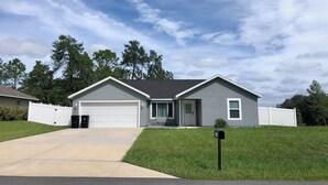 A single-story house with a garage, a front porch, and a mailbox. - Jake's Cozy Corner (Ocala)