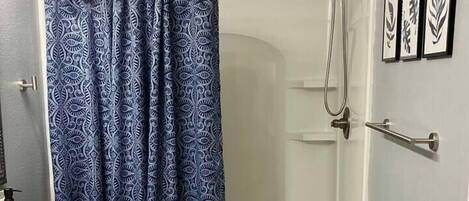 A bathroom with a shower, a sink, and a toilet.