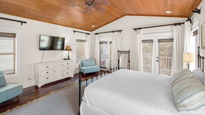 A bedroom with a large bed, a TV mounted on the wall, a wooden ceiling, and a window with blinds. - Seacrest Beach Home for 17, Huge Resort Pool & Beach Tram (Panama City Beach)