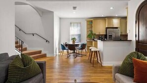 Un salon moderne avec un canapé, une table basse et un escalier.