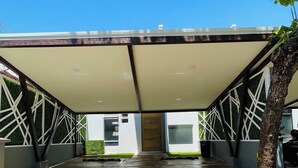An outdoor covered area with a modern design, featuring a metal frame and a white canopy. - Casa Lapa Roja (Jacó)