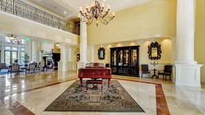 A grand lobby with a piano, ornate chandeliers, and classical decor. - Steps From Baytowne Wharf With Pool & Private Beach Access (Miramar Beach)