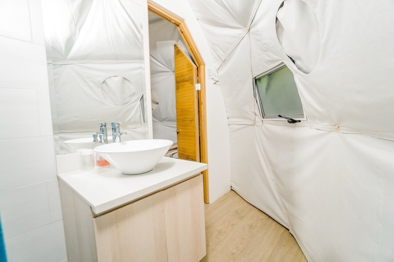 Ein modernes Badezimmer mit Waschbecken, Holzschrank und kleinem Fenster.