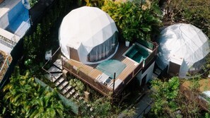 A dome-shaped building with a swimming pool, surrounded by lush greenery. - Tortuga Verde Glamping (Sardinal)